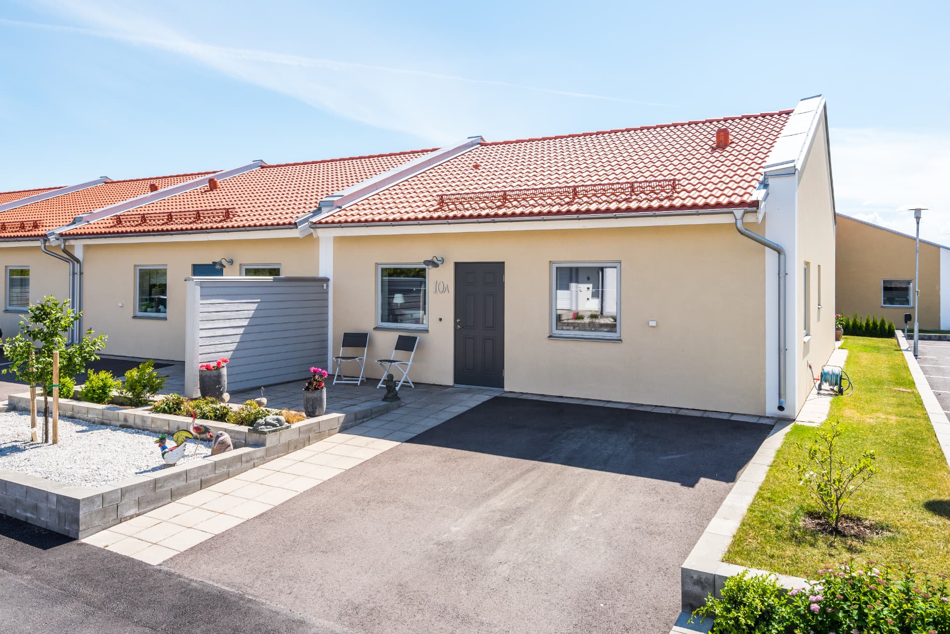Entré med egen parkering och planteringar
